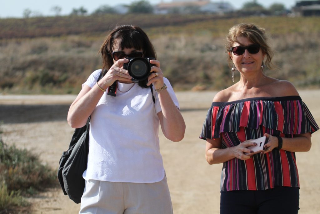 Two women taking photos on the beach in Portugal