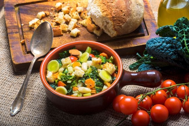 rustic bowl of ribollita soup with bread and tomatoes