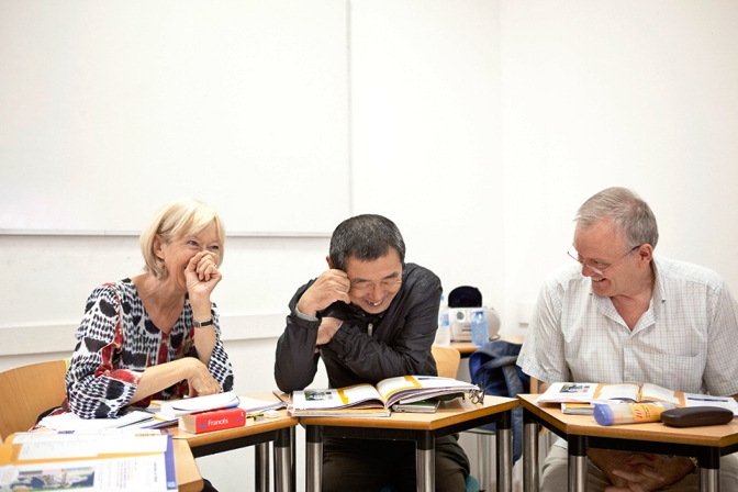 Over 50 students laughing in classroom studying Spanish