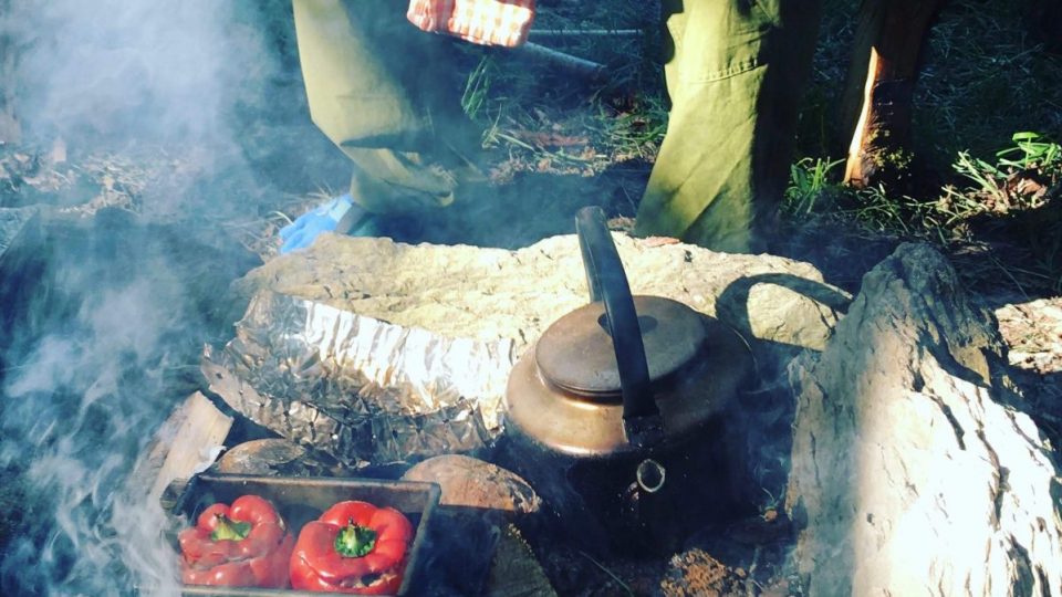 camp fire making meal of red peppers