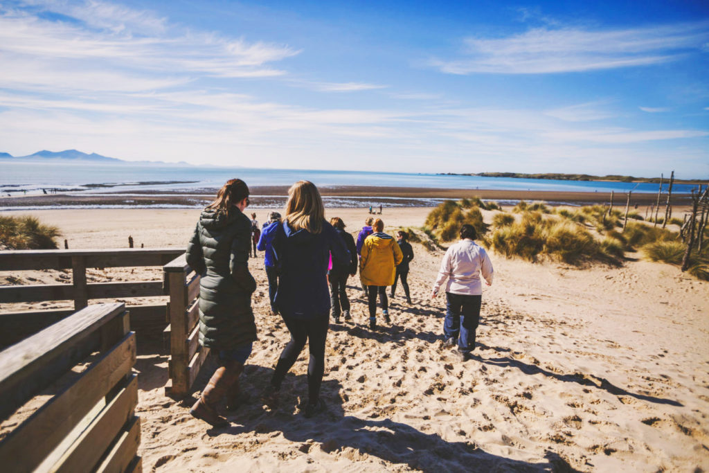 women walking on to beach in Wales