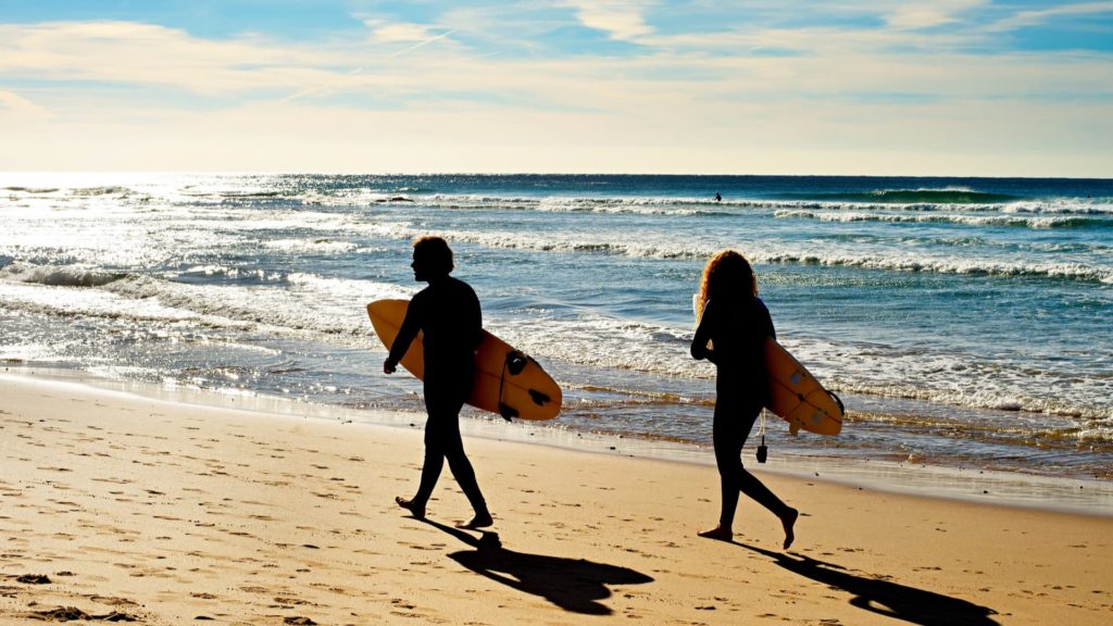 surfers on beach in portugal