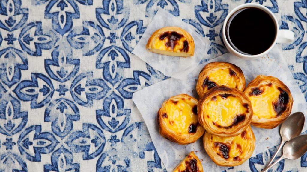 coffee and Portuguese tart on tiled table