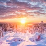 sunset over snowy lapland landscape