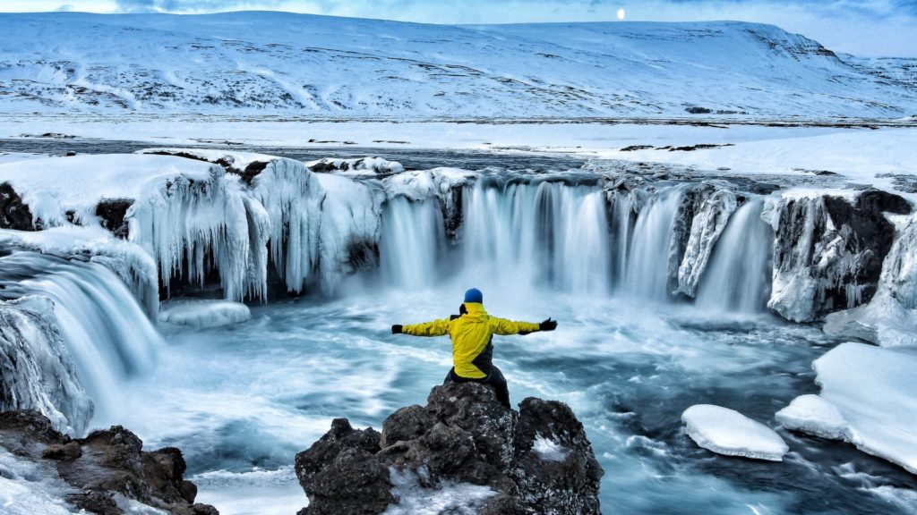 man looking at winter canyon in iceland