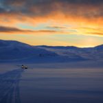 two snowmobiles in the distance in norway