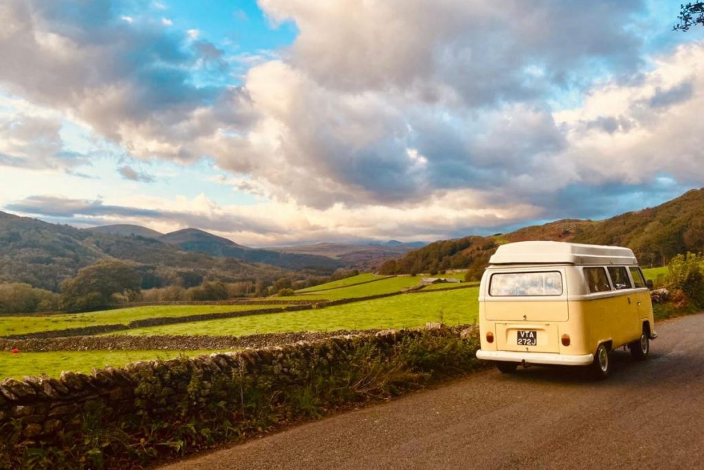 yellow campervan being driven in the lake district