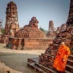 monk in front of temples in thailand