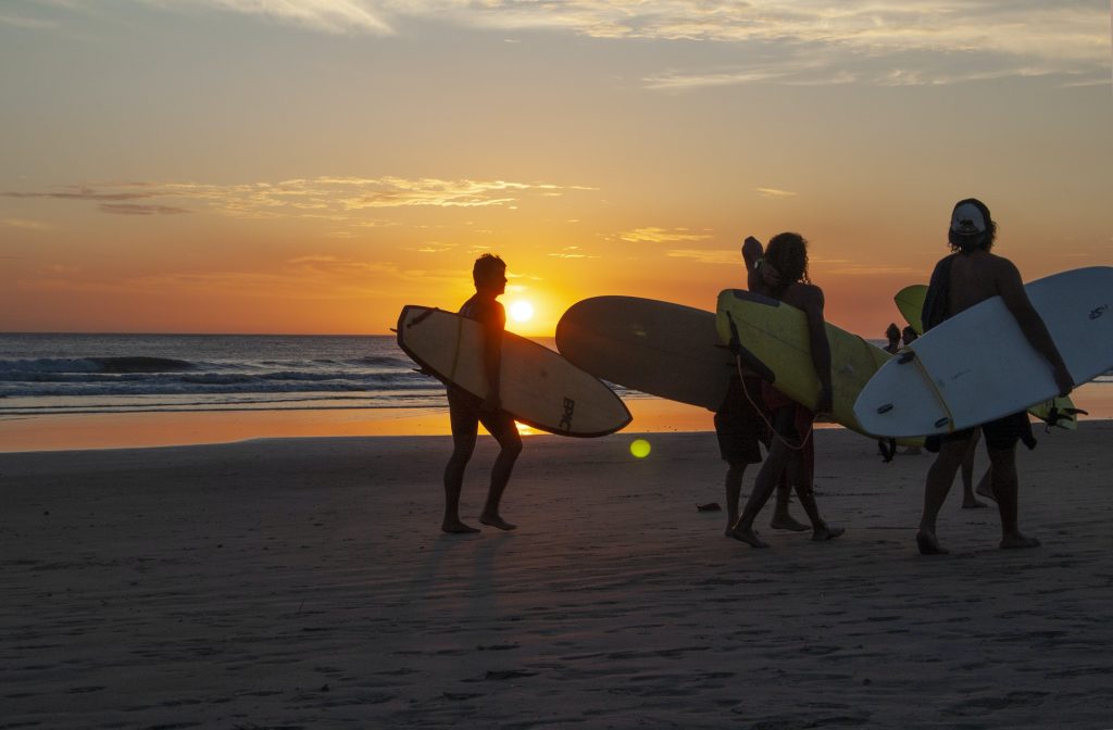 surfers in costa rica at sunset