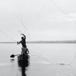 man fishing on a lake in uganda